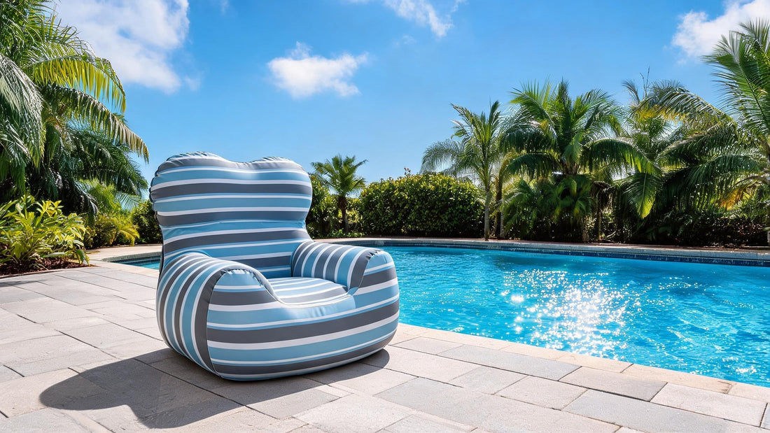 Pouf gonflable L'Horizon rayé au bord d'une piscine avec palmiers